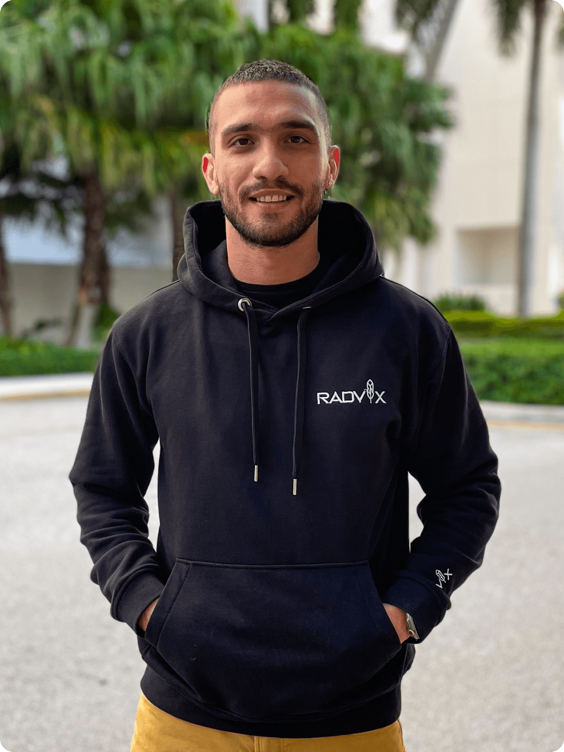 Photo of Nima Hosseinzadeh, Founder, standing outdoors and wearing a Radvix hoodie, smiling.