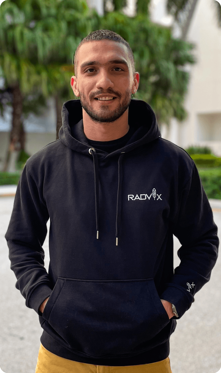 Photo of Nima Hosseinzadeh, Founder, standing outdoors and wearing a Radvix hoodie, smiling.